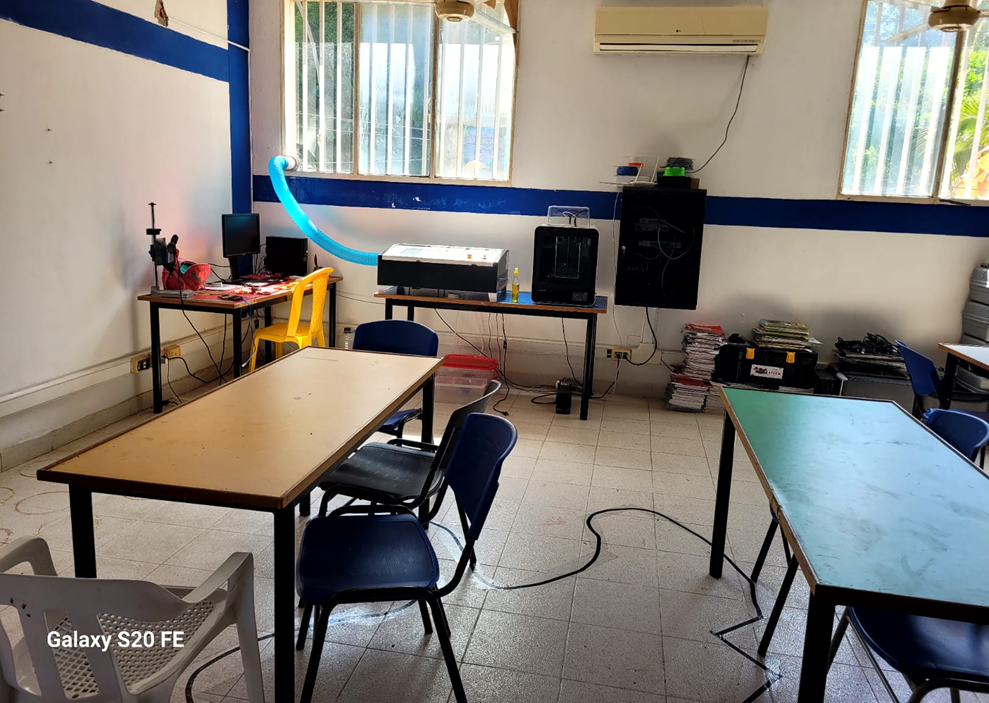 Sala de Robótica – vista general: aula tecnológica con mesas de trabajo organizadas, equipos de robótica educativa y computadores, espacio amplio y adecuado para actividades de programación, ensamblaje y desarrollo de proyectos tecnológicos.
