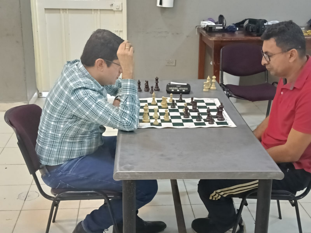 Carlos Alberto Jaimes Bravo, con piezas blancas, analiza la posición frente a Ángel Gabriel Suárez Durán durante su primer enfrentamiento de la fase interzonal de ajedrez Occidente vs. Puerto Boyacá.