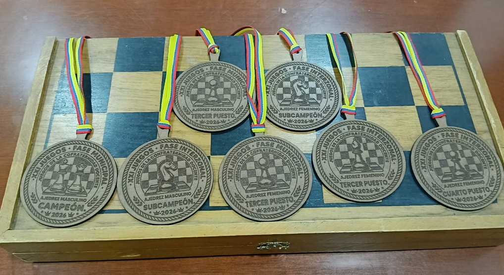 Medallería elaborada para la fase interzonal de ajedrez de los XXI Juegos de la Confraternidad Docente, con reconocimientos para los primeros lugares de las ramas masculina y femenina, dispuesta sobre un tablero de ajedrez de madera.
