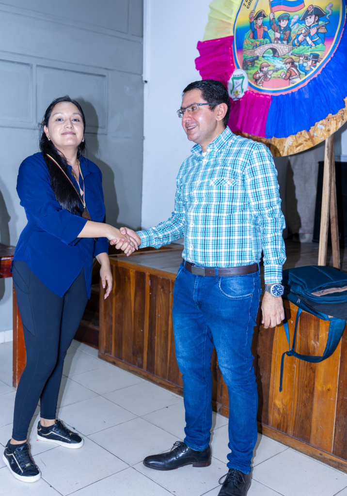 La campeona de la rama femenina de la fase interzonal de ajedrez saluda a Carlos Alberto Jaimes Bravo durante la ceremonia de premiación en la I.E. John F. Kennedy.